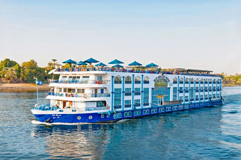 Bateau de croisière sur le Nil entouré de palmiers en Égypte