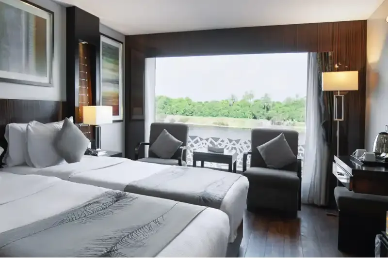 Cabina elegante sulla Motonave Le Fayan: ambienti moderni, comfort esclusivo e vista panoramica sul Nilo per una crociera di lusso indimenticabile.